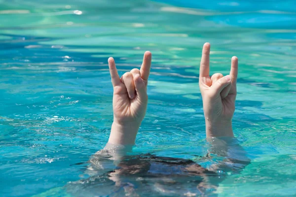 Two hands out of water in rock gesture — Stock Photo, Image