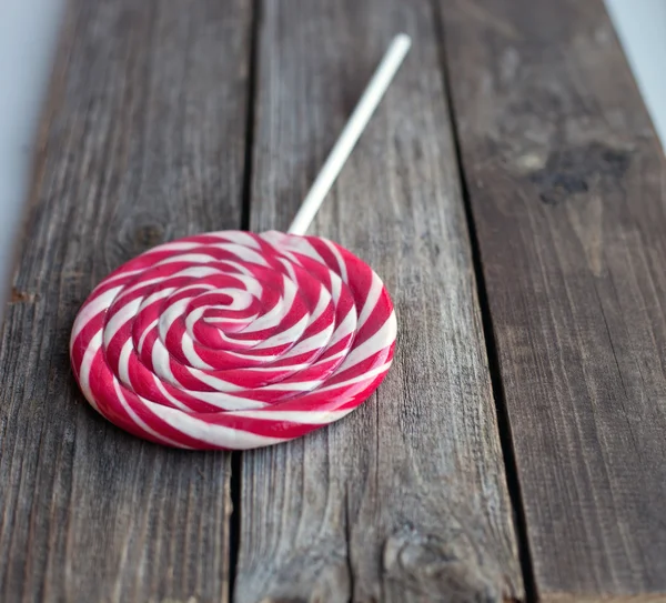 Red and white sweet lollipop on wooden table — Stock Photo, Image