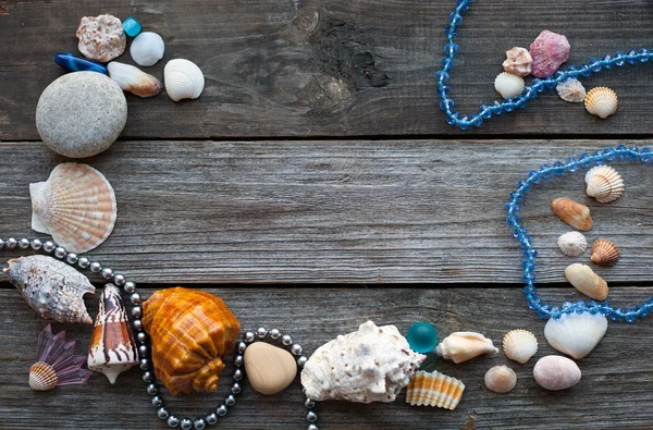 Seashells and pebbles on the wooden table — Stock Photo, Image