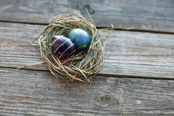 Easter decoration - glass eggs in a nest on table — Stock Photo, Image