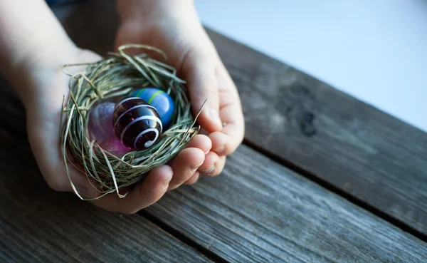 Пасхальное украшение - стеклянные яйца в руках — стоковое фото