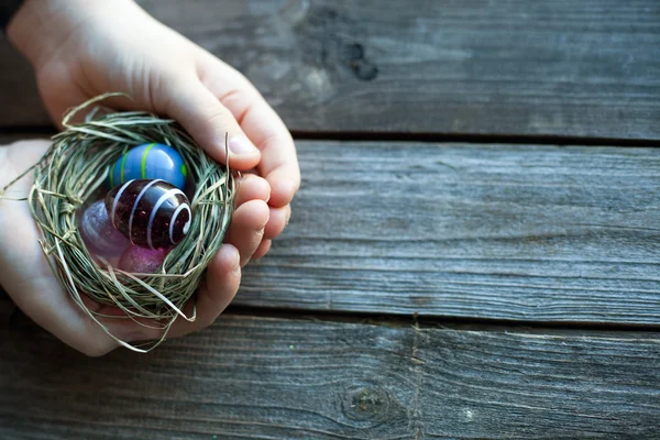 Easter decoration - glass eggs in hands — Stock Photo, Image