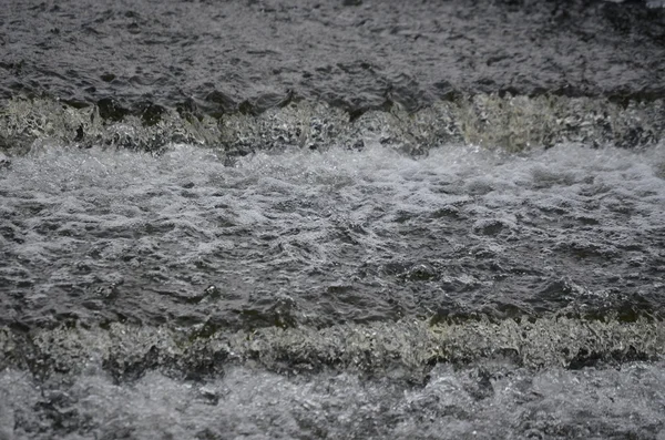 Agua que fluye rápidamente en el río de invierno — Foto de Stock