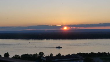 Güneş tepelerin üzerinden batıyor. Gün batımında nehir manzarası.