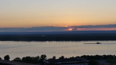 Güneş tepelerin üzerinden batıyor. Gün batımında nehir manzarası.