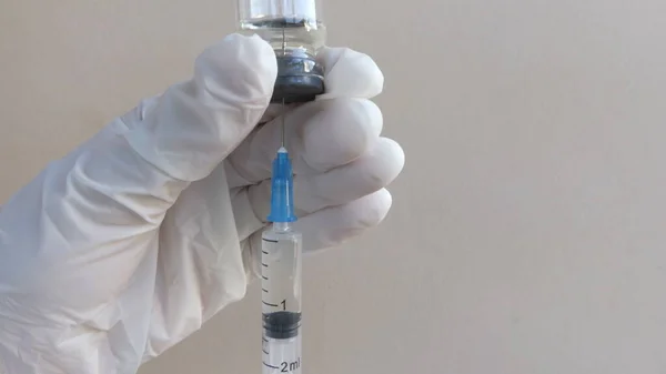 Az orvos egy átlátszó ampullából egy fecskendőbe szívja fel a vakcinát. Vírus vakcina közelkép. — Stock Fotó