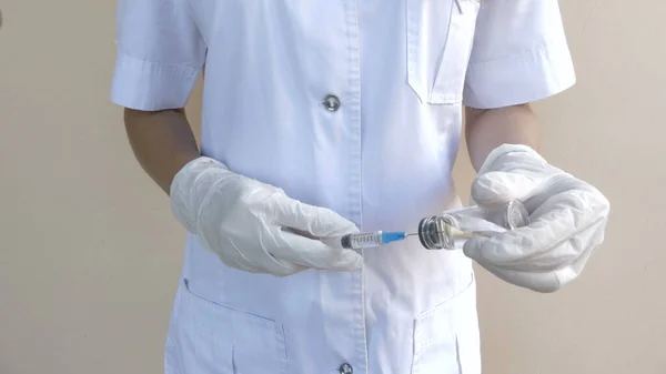 Az orvos egy átlátszó ampullából egy fecskendőbe szívja fel a vakcinát. Vírus vakcina. — Stock Fotó