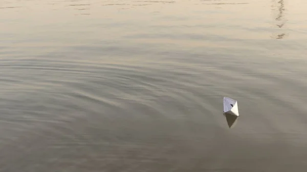 紙のボートは川の下に浮かび、燃える。紙からの折り紙. — ストック写真