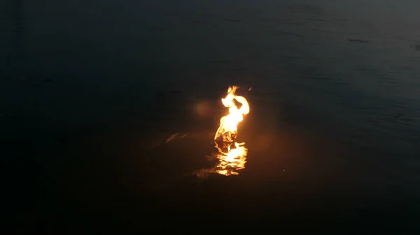 Kağıttan bir tekne nehirde yüzüyor ve gecenin bir yarısı yanıyor. Kağıttan Origami. — Stok fotoğraf