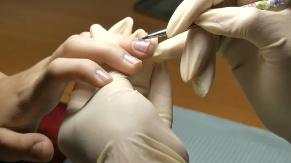 De manicure brengt de bio gel aan op de nagels van de klant. — Stockfoto