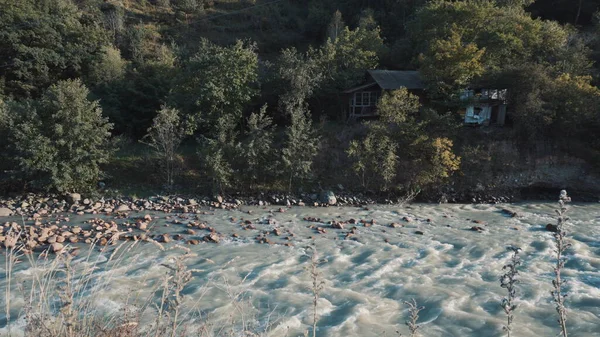 O rio azul flui contra a colina verde. O rio da montanha flui rapidamente. — Fotografia de Stock