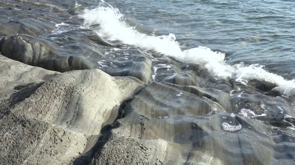 The waves hit the rocks in close-up. High tide at sea. — Stock Photo, Image