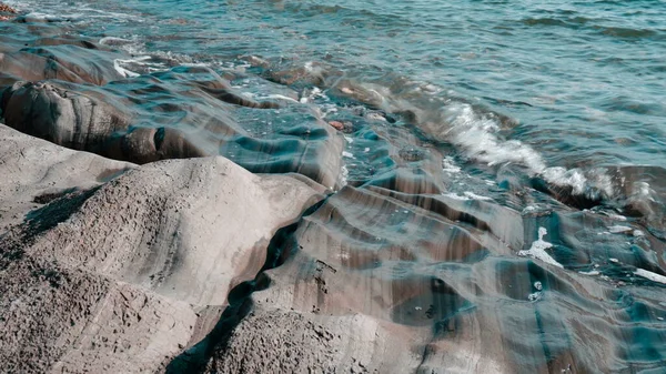 The waves hit the rocks in close-up. High tide at sea. — Stock Photo, Image