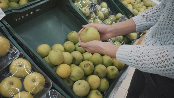 Mladá žena sbírá na trhu zelená jablka. Dívčí ruce zblízka. — Stock fotografie