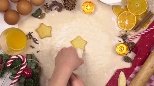 Una mujer joven decora las galletas navideñas festivas con glaseado de estrellas de colores. Vista desde arriba. — Vídeo de stock