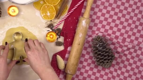 Een jonge vrouw maakt een traditioneel feestelijk kerstkoekje in de vorm van een mens. In het deeg wordt een figuru geplaatst. Camera beweegt bovenaanzicht. — Stockvideo