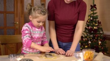 Genç bir annesi olan bir kız geleneksel Noel kurabiyelerini çizme şeklinde yapar. Hamurun içine bir heykel konur..
