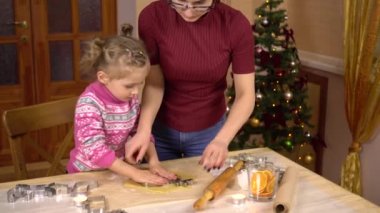 Genç bir annesi olan bir kız geleneksel Noel kurabiyelerini geyik şeklinde yapar. Hamurun içine bir heykel konur..