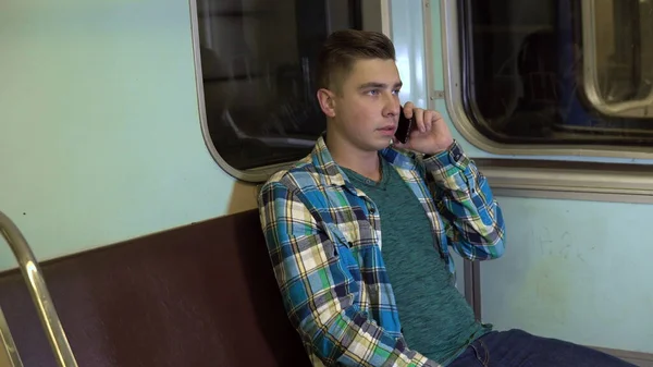 Un joven habla por teléfono en un tren subterráneo. Viejo vagón de metro — Foto de Stock