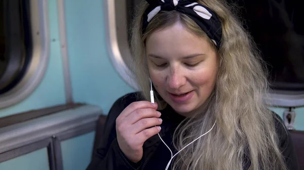 Вагітна жінка розмовляє по телефону через навушники до поїзда метро. Старий вагон метро — стокове фото