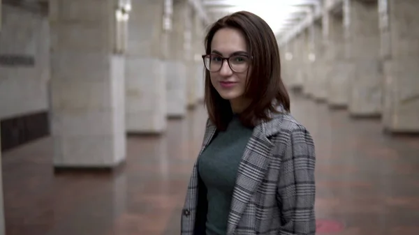 O tânără se apropie de trenul din metrou. O fată în haină şi ochelari — Fotografie, imagine de stoc