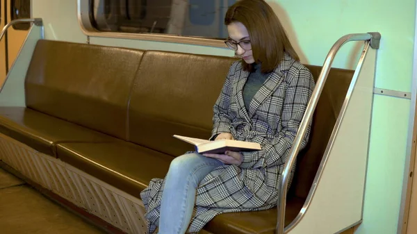 Uma jovem está lendo um livro em um trem de metrô. Velho carro de metrô — Fotografia de Stock
