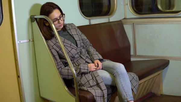 한 젊은 여자가 지하철에서 잠 이 들었다. 오래 된 지하철 차량 — 스톡 사진