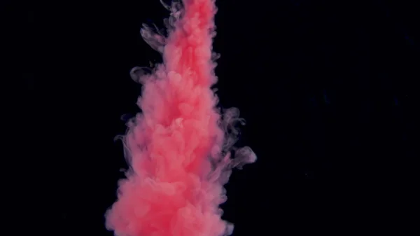 本物の赤いペンキが水に落ちる。水中で渦巻くインク。黒い背景に孤立したインク衝突の雲。ビューを閉じる — ストック写真