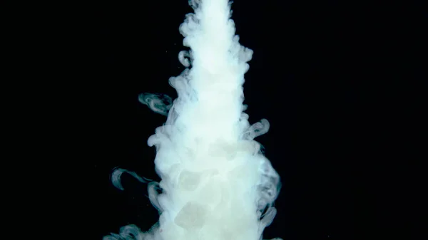 Gotas de pintura blanca tiro real en el agua. Tinta arremolinándose bajo el agua. Nube de colisión de tinta aislada sobre fondo negro. Vista de cerca — Foto de Stock