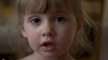 Küçük kız kameraya yakından bakıyor.