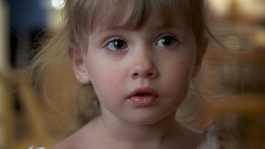 Küçük kız kameraya yakından bakıyor.