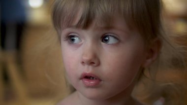 Küçük kız kameraya yakından bakıyor.