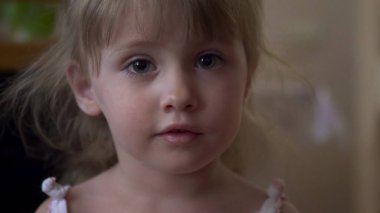 Küçük kız kameraya yakından bakıyor.