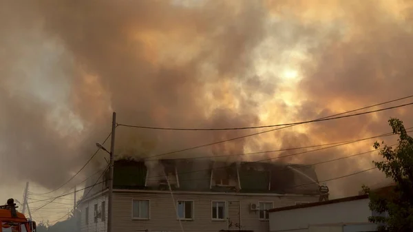 İtfaiyeciler bir evi söndürür. Konut binasının büyük yangını. Çok duman.