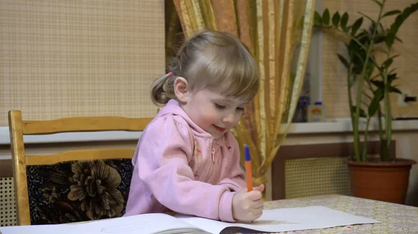 A menina sentada a uma mesa e desenha o álbum — Fotografia de Stock