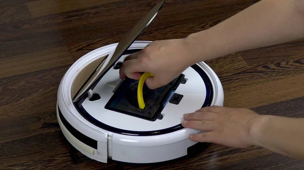 A dirty filter is pulled out of a vacuum cleaner robot. Automatic white round vacuum cleaner — Stock Photo, Image