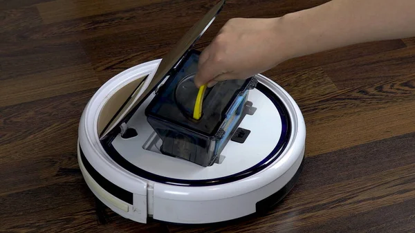 Elektrikli süpürge robotuna yeni bir filtre takar otomatik beyaz yuvarlak elektrikli süpürge.