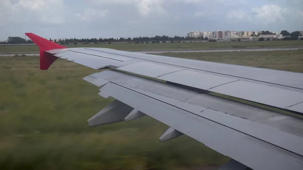 飛行機は地面を走行する。飛行機の窓から翼までの眺め. — ストック写真