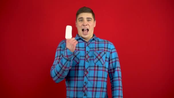 若い男達の人差し指は包帯をされ痛がっている。赤い背景で撮影. — ストック動画