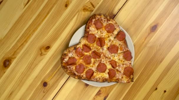 Pizza en forma de corazón para San Valentín. La cámara gira y se acerca a la pizza. Vista desde arriba. — Vídeo de stock