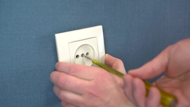 El electricista instala el enchufe en la pared con un destornillador especial. Primer plano. — Vídeos de Stock