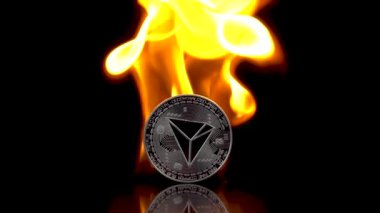 Tron - TRX madeni parası izole edilmiş siyah bir arkaplanda alev alır. Yavaş çekim 250 fps.