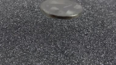 TRON kripto para birimi gümüş parıltıların üzerine düşer. Gerçek metal TRX parası. Yavaş çekim 500fps.