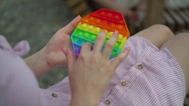 Elinde bir popit olan genç bir kadın oturuyor. Kız sakinleşmek için pop çalıyor..