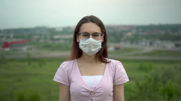 Jovem mulher usando óculos usando uma máscara médica. — Fotografia de Stock