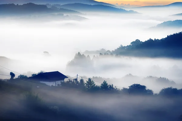 Casa en la mañana con montañas brumosas — Foto de Stock