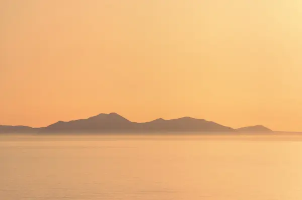 Mgliste góry nad morze z kolor pomarańczowy — Zdjęcie stockowe