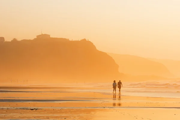 Couple walking on beach at sunset — Stock Photo, Image