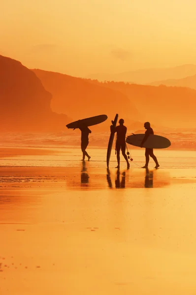 Surfers στην ακτή στο ηλιοβασίλεμα — Φωτογραφία Αρχείου