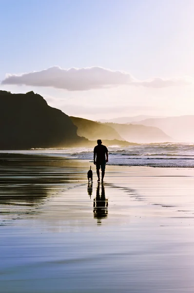 Man gå ut med hunden på stranden — Stockfoto